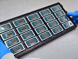 A tray of Intel Core Ultra Processors held up by a gloved worker.